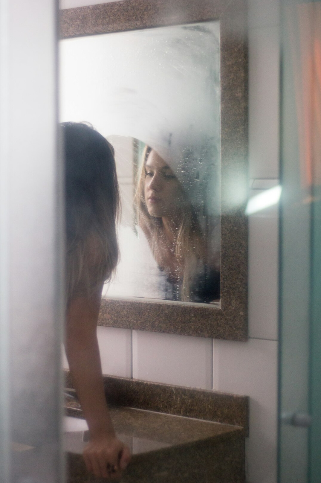 woman with hidden face in mirror